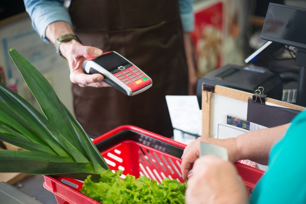 Cliente pagando com cartão no caixa de uma loja